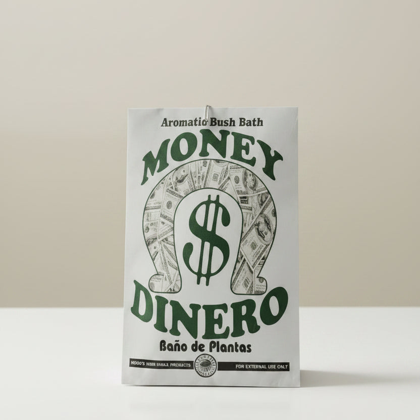 A white rectangular fabric plant pot holder with a green and black graphic design featuring the words 'MONEY DINERO' and 'Aromatic Bush Bath' on a light wood background.