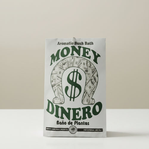 A white rectangular fabric plant pot holder with a green and black graphic design featuring the words 'MONEY DINERO' and 'Aromatic Bush Bath' on a light wood background.