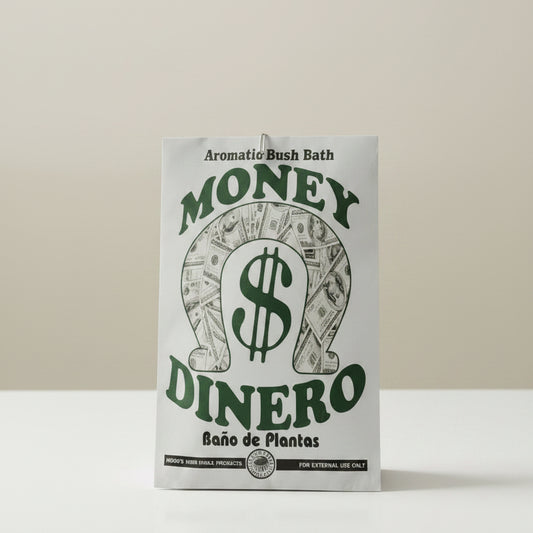 A white rectangular fabric plant pot holder with a green and black graphic design featuring the words 'MONEY DINERO' and 'Aromatic Bush Bath' on a light wood background.